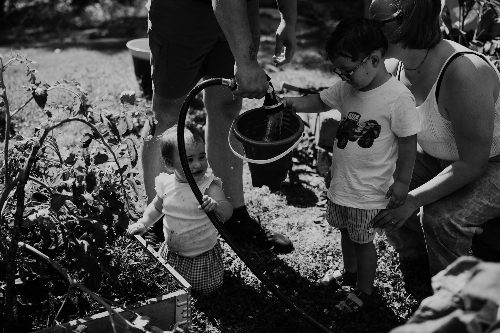 Whole family hose fight: "Family playing with water hose during outdoor Day in the Life session in Trinity NC photographed by NC documentary family photographer Bekah Cabrejos