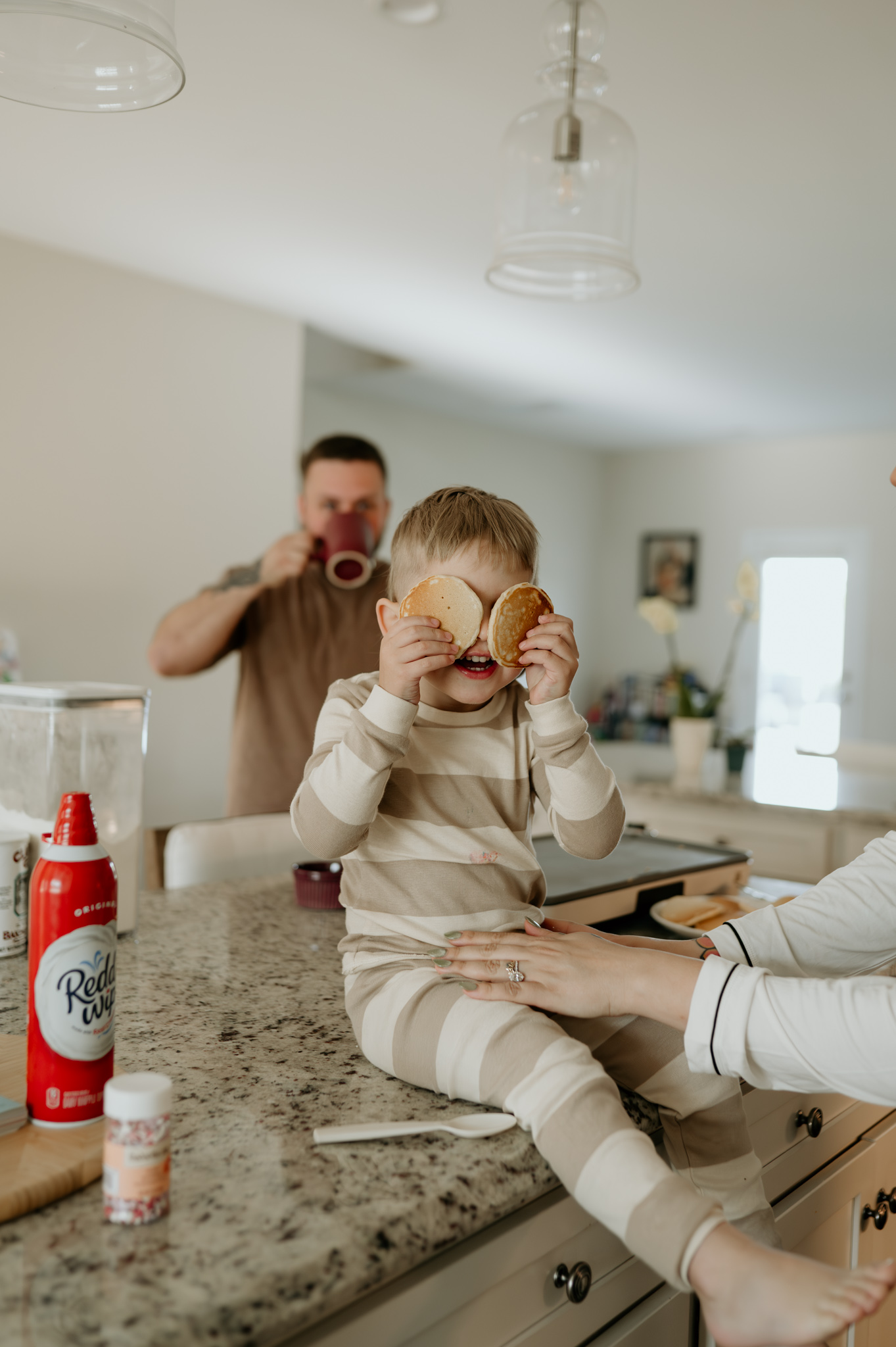 Family with dogs in kitchen during in home Day in the Life session in High Point NC photographed by NC documentary family photographer Bekah Cabrejos